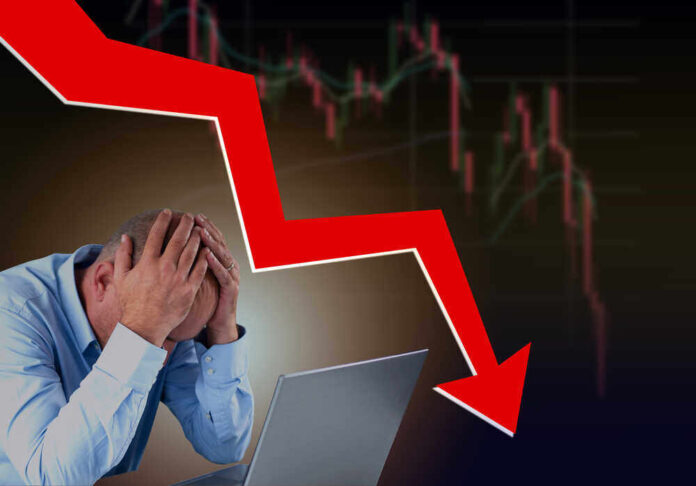 shutterstock_2009223203.jpg featured image Man stressed over falling stock market graph.