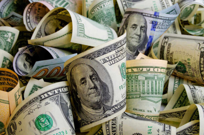 shutterstock_518001346.jpg featured image Rolled U.S. dollar bills in various denominations.