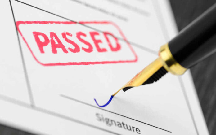 651111658 featured image Pen signing a Passed stamped document.