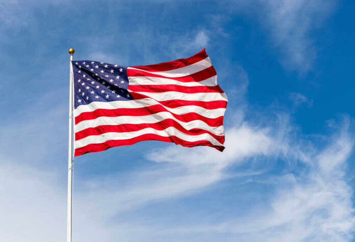 shutterstock_1783485566.jpg featured image American flag waving against a blue sky.