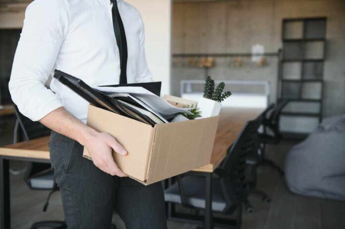 shutterstock_2290780995.jpg featured image Person carrying box of office supplies in workspace.