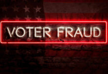Neon sign reading Voter Fraud on American flag background.