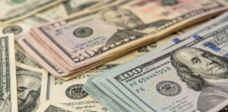 Stacks of US dollars featuring Benjamin Franklin and Ulysses S. Grant.