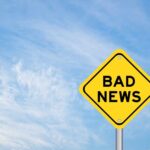 Yellow sign reads bad news in sky