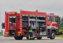 Firefighter accessing equipment on a parked fire truck