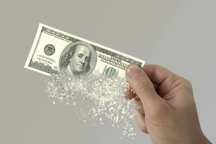 shutterstock_580278601.jpg featured image Hand holding a disintegrating hundred dollar bill.