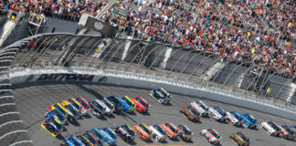 Race cars on Daytona track with large audience watching