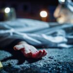 Watch: Car Bomb Suspect DEAD – Mysterious Circumstances! Crime scene with covered body and hand exposed.