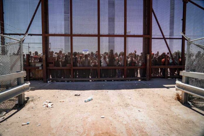 shutterstock_2298883197.jpg featured image People standing behind a fence on a dusty path.