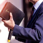 Man holding a Bible during a speech