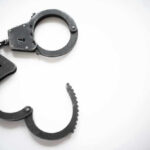 VIDEO: Pilot Arrested In Cockpit — Shocking Charges Revealed Open metal handcuffs on white background