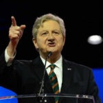John N Kennedy pointing and speaking at a podium