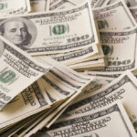 Stacks of one hundred dollar bills scattered