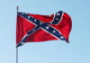 Confederate flag waving against a clear blue sky