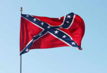 Confederate flag waving against a clear blue sky