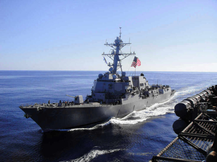 Warship with American flag sailing in the ocean