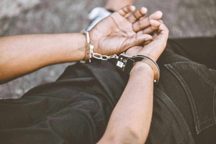 Person in handcuffs with hands behind back.