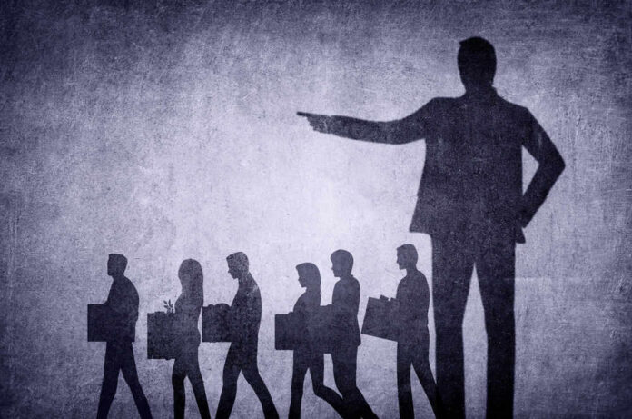 shutterstock_2254036017.jpg Shadows of laid-off workers walking, large figure pointing.