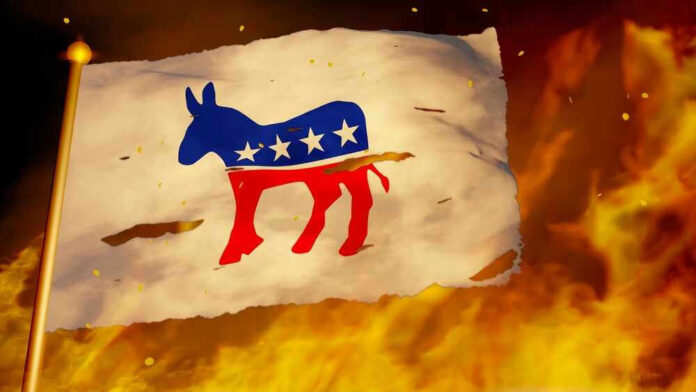 Torn Democrat flag burning amid flames and embers.