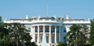 The White House, front view with fountain and flag.
