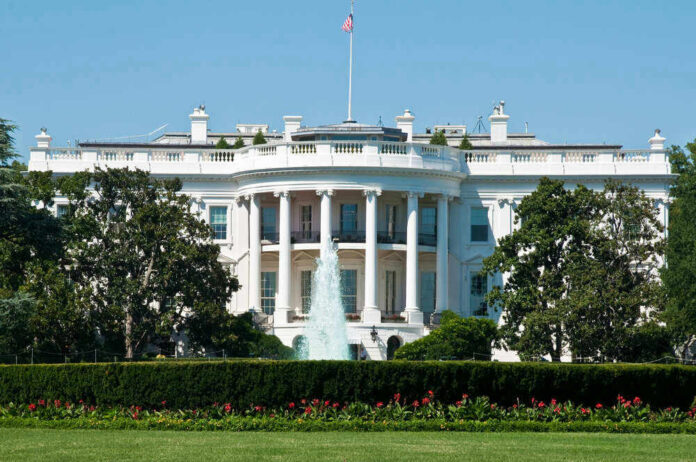 The White House, front view with fountain and flag.