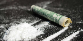 Cocaine lines with rolled banknote on surface