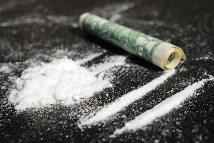Cocaine lines with rolled banknote on surface