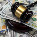 Gavel on pile of hundred dollar bills