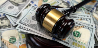 Gavel on pile of hundred dollar bills