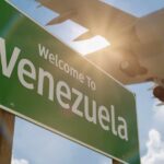 Venezuelans Encouraged to Return Home Welcome sign to Venezuela with an airplane flying overhead