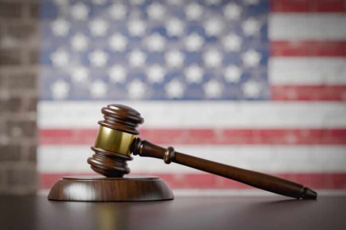 shutterstock_2654340477.jpg A wooden gavel resting on a sound block with an American flag background