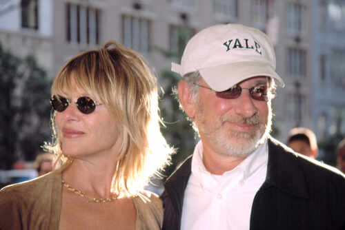 Two individuals at a public event, one wearing sunglasses and a Yale cap