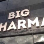 Sign displaying the words BIG PHARMA on a glass building