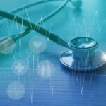 Legend DEFIES Doctors — She’ll RACE! A stethoscope on a wooden surface with digital health icons and a heartbeat graph overlay