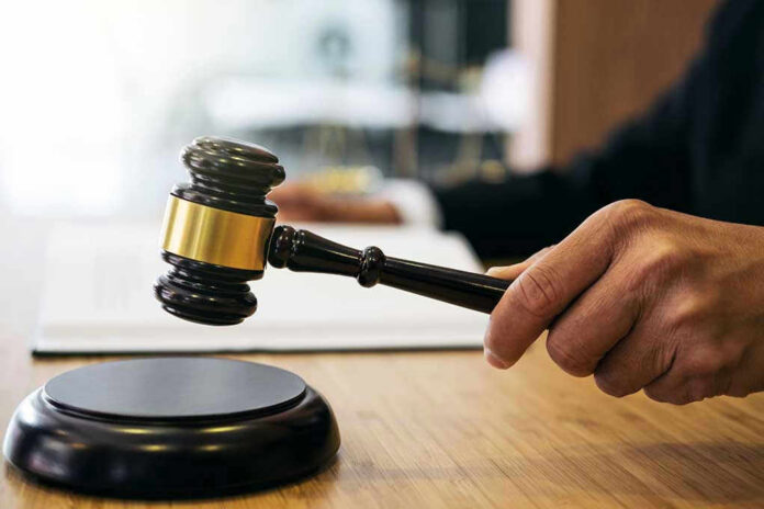 Gavel in judges hand about to strike.