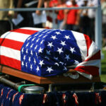 With Trump Attending, First War Dead Come Home American flag draped over a casket at ceremony.