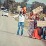 Counterculture Legend DEAD at 84 Group of young people hitchhiking on a rural road with signs