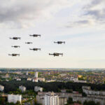 Iranian Drone Strikes Hit AWS Data Centers Drones flying over a cityscape under cloudy sky.