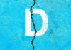 White letter D on cracked blue surface.