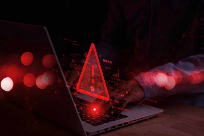 Warning symbol over laptop with user.