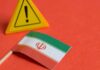 Iranian flag next to a caution sign on a red background