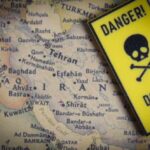 A danger sign placed over a map of the Middle East