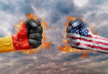 Two fists, one painted with the German flag and the other with the American flag, clashing against a fiery background
