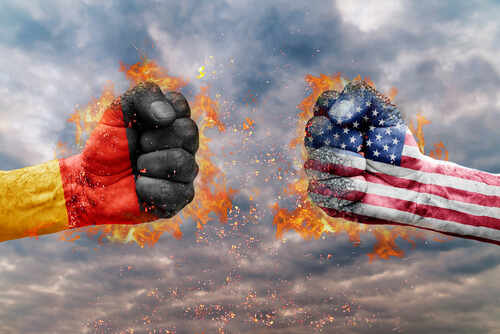 Two fists, one painted with the German flag and the other with the American flag, clashing against a fiery background