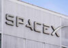 Delta DUMPS Musk — Billion-Dollar Blow to SpaceX SpaceX building logo against blue sky.