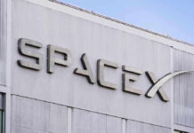 SpaceX building logo against blue sky.