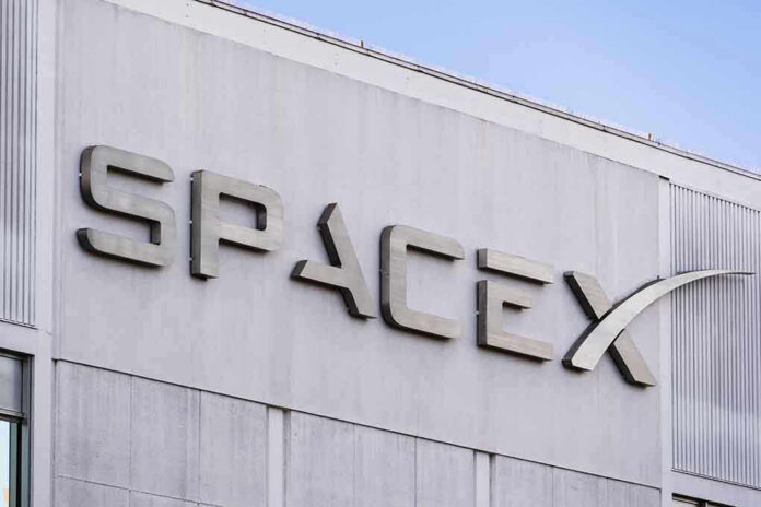 SpaceX building logo against blue sky.