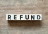Wooden blocks spelling the word 'REFUND' on a wooden surface