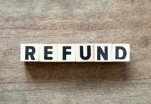 Wooden blocks spelling the word 'REFUND' on a wooden surface