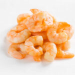 Endless Shrimp RETURNS After Previous Catastrophe A pile of cooked shrimp on a white background